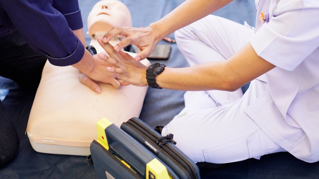 Basic life support instructor teaches how to pump a heart on silicone rubber dummy.