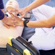 Basic life support instructor teaches how to pump a heart on silicone rubber dummy.