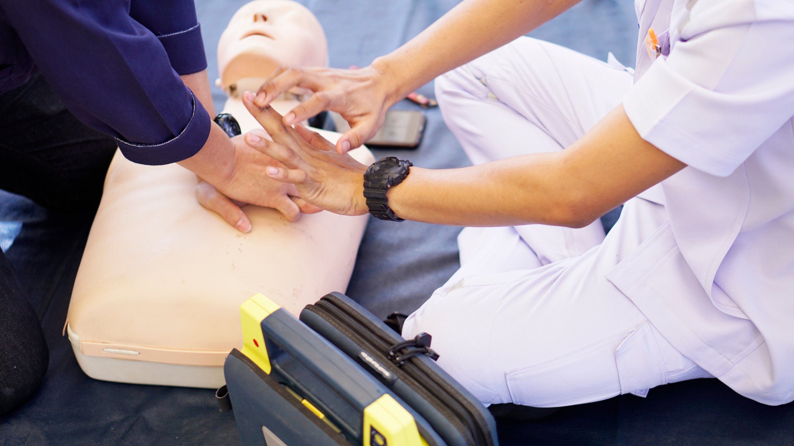 Basic life support instructor teaches how to pump a heart on silicone rubber dummy.